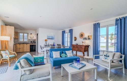 un salon avec un canapé bleu et des chaises dans l'établissement Nice Home In Saint-Denis-Doléron, à Saint-Denis-dʼOléron