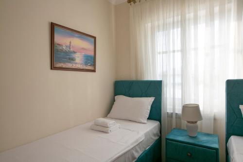 a bedroom with two beds and a picture on the wall at Luxury Apartments Montesan in Sveti Stefan