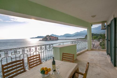 a balcony with a table and a view of the water at Luxury Apartments Montesan in Sveti Stefan