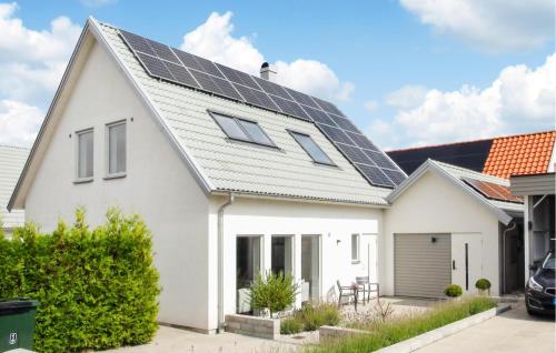 a white house with solar panels on the roof at 4 Bedroom Cozy Home In Ystad in Ystad