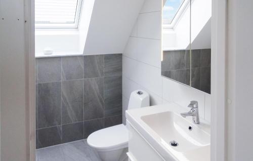 a bathroom with a white toilet and a sink at 4 Bedroom Cozy Home In Ystad in Ystad