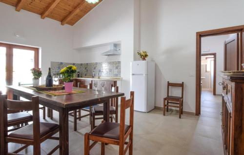 a kitchen with a table and chairs and a refrigerator at Villa Rossella in Gaggi