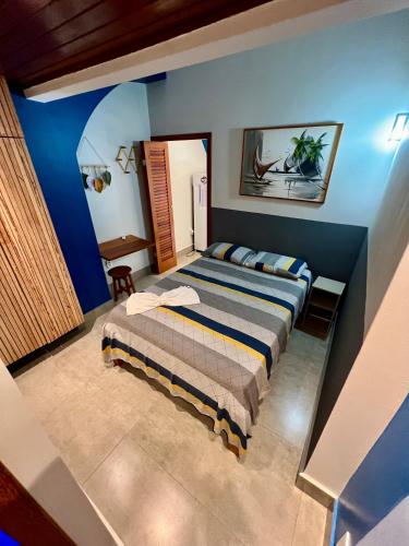 a bedroom with a bed and a blue wall at Flats Theo Peleteiro Praia da concha Flatitacareconcha in Itacaré