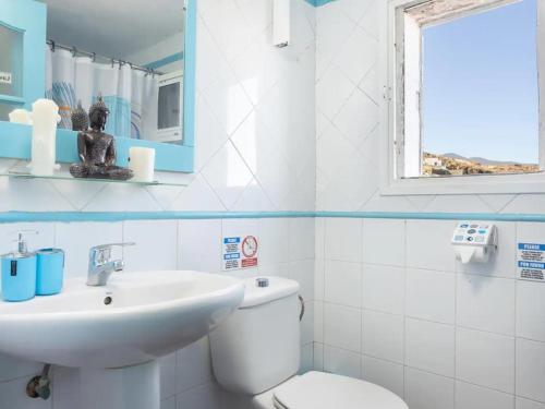 un bagno con un water, un lavandino e uno specchio di Casa en el mar a Candelaria