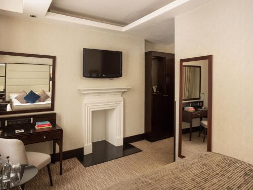 a hotel room with a bed and a television on the wall at Montcalm Brewery Townhouse in London