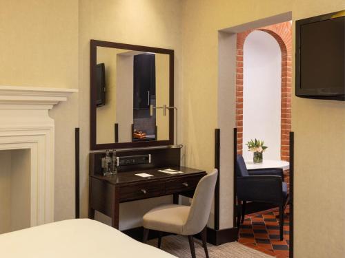 a hotel room with a desk and a mirror at Montcalm Brewery Townhouse in London