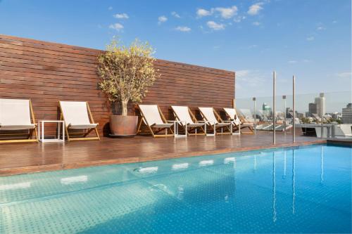 a group of chairs and a swimming pool on a building at Melia Madrid Serrano in Madrid
