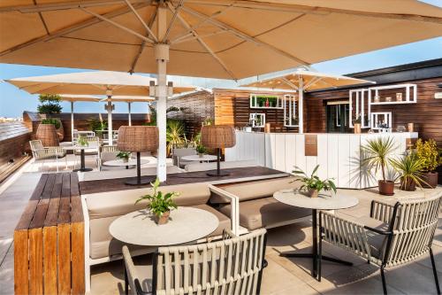a patio with tables and chairs and umbrellas at Melia Madrid Serrano in Madrid
