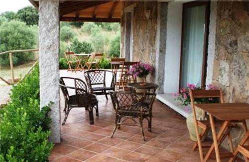 een patio met stoelen en tafels en een tafel bij B&B Sa Soliana in Telti