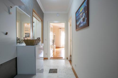 a hallway with a white kitchen with a painting on the wall at Luxury Apartments Montesan in Sveti Stefan