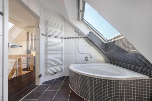 a bathroom with a tub and a window in it at Schotstek in Wunstorf