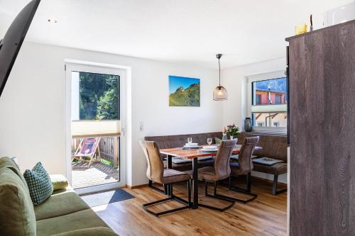 a dining room and living room with a table and chairs at Berghoamat Nauders in Nauders