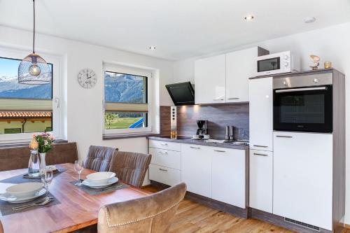 a kitchen and dining room with a table and chairs at Berghoamat Nauders in Nauders