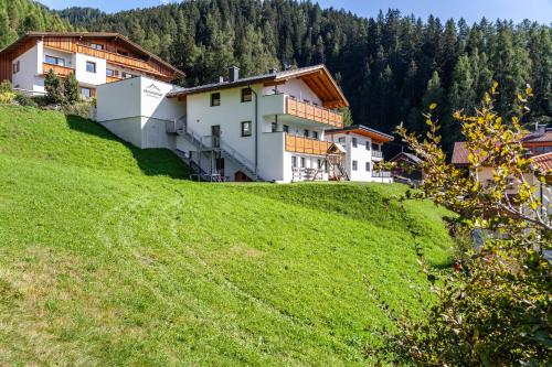 a building on top of a green hill at Berghoamat Nauders in Nauders