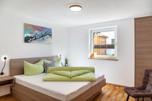 a bedroom with a bed with green pillows on it at Berghoamat Nauders in Nauders
