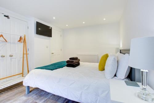 a white bed with a bag on it in a room at Luxury 2 Bed Apartment with Stunning Sea View Steps from Old Town and Dreamland in Margate
