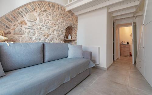 a living room with a stone wall and a couch at Avgoustinos house in Chios