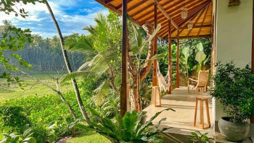 a porch of a house with chairs and trees at The Jungle Loft Galle in Galle