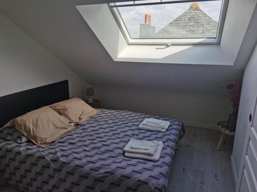 une chambre avec un lit avec deux serviettes dessus dans l'établissement La maison Kerserho, à Plouhinec