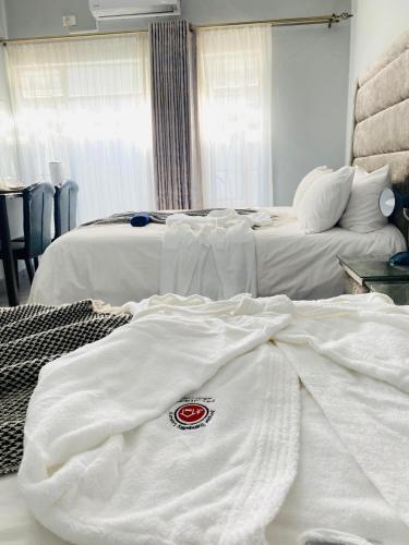 a hotel room with two beds with white sheets at President Guest Lodge in Louis Trichardt