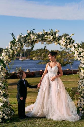 a bride and groom standing under an arch with flowers at Mövenpick Resort Aswan in Aswan