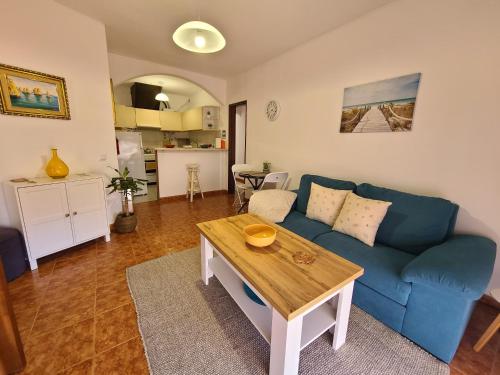 Una sala de estar con un sofá azul y una mesa. en Chez Marlene, en Lagos