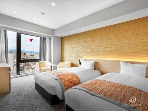 a hotel room with two beds and a large window at Daiwa Roynet Hotel Matsuyama in Matsuyama