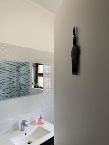 a white bathroom with a sink and a mirror at A Casa da Carrasqueira, Sesimbra in Sesimbra