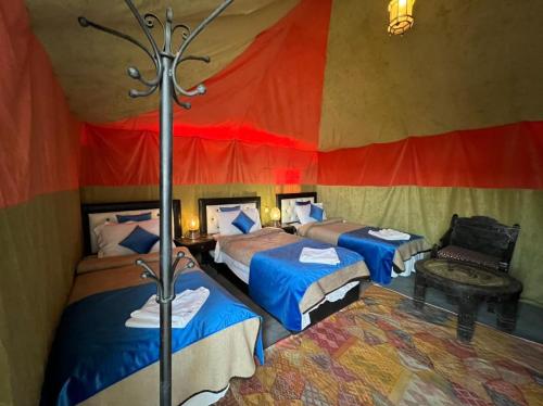 a room with three beds in a tent at hello desert camp in Erfoud