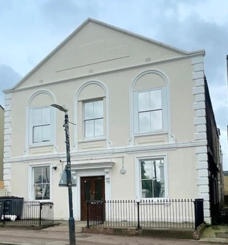 a white house with a black fence in front of it at Cozy Fully Equipped Loft Studio City Centre in Maidstone