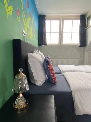 a bedroom with a bed with white pillows and a window at B&B nancy in holland met eigen badkamer , independent bathroom in Aalten