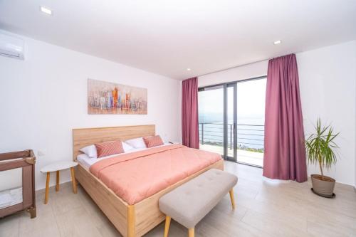 a bedroom with a bed and a large window at Villa Deavista by Villsy in Matulji