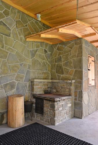 a stone fireplace in a room with a wooden ceiling at Pokoje Gościnne u Wioli in Jurgów