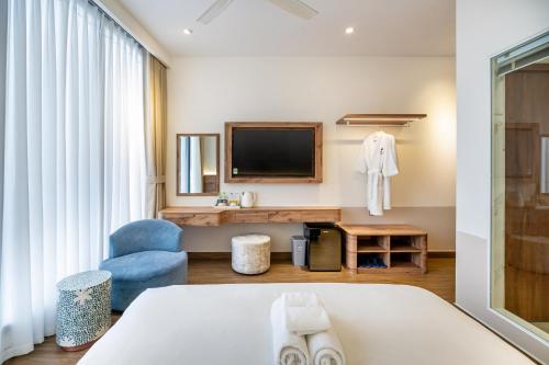 a hotel room with a bed and a television at Aquatel Vung Tau in Vung Tau