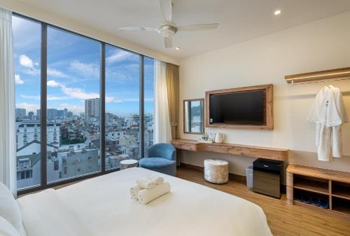 a hotel room with a bed and a large window at Aquatel Vung Tau in Vung Tau
