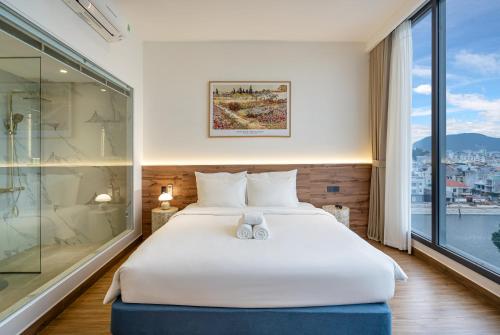 a bedroom with a large white bed and a window at Aquatel Vung Tau in Vung Tau