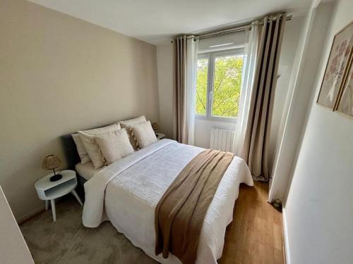 une chambre avec un grand lit et une fenêtre dans l'établissement Iris - T2 cosy Chelles, à Chelles