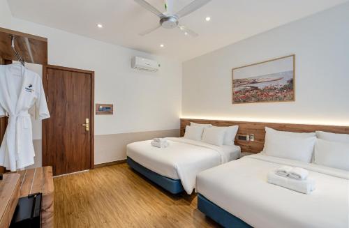 a hotel room with two beds and a robe at Aquatel Vung Tau in Vung Tau