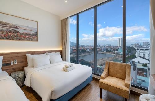 a hotel room with a bed and a chair at Aquatel Vung Tau in Vung Tau