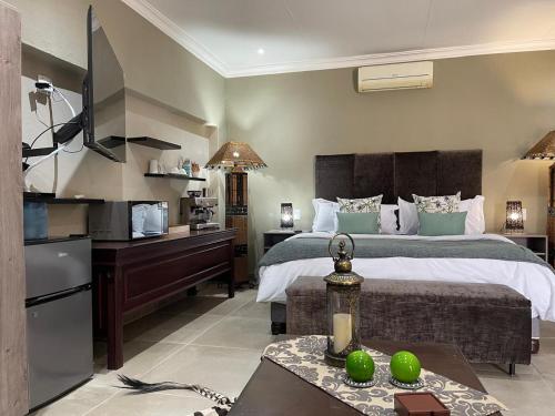 a bedroom with a bed and a desk with a kitchen at Mountain Dew Guest House in Noordkaap
