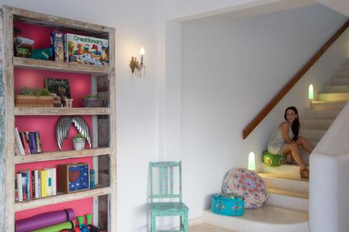 a woman sitting on the stairs in a house at LiveTulum in Tulum
