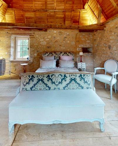 une chambre avec un grand lit blanc dans une pièce dans l'établissement Romantic cottage in garden of Château de La Motte-Feuilly, à La Motte-Feuilly
