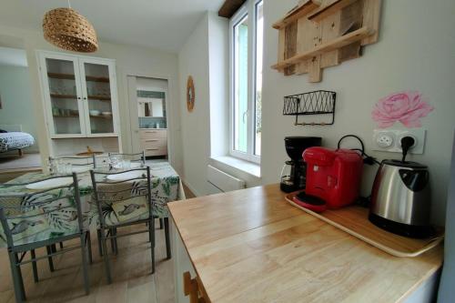 - une cuisine avec une table et une cafetière dans l'établissement Les pivoines au calme 15min du zoo, à Meusnes