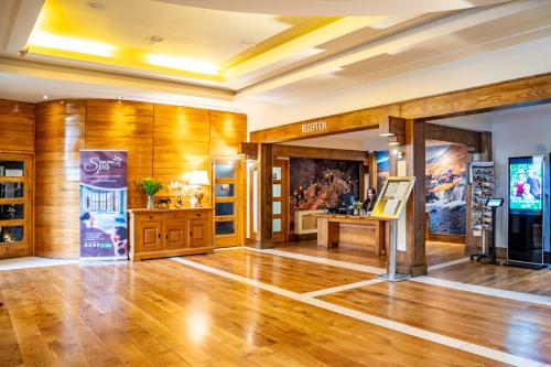 a large room with wooden walls and a wooden floor at Delphi Resort Hotel & Spa in Leenaun