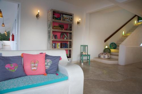 a living room with a white couch and a staircase at LiveTulum in Tulum
