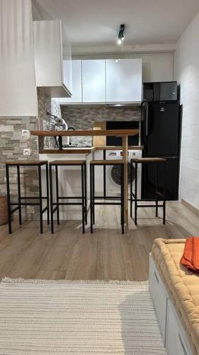 Il comprend une cuisine équipée d'une table et d'un réfrigérateur noir. dans l'établissement Studio Paris 19, à Paris