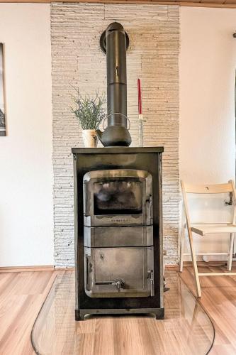 a stove in a room with a table and a chair at Apartment Ferienwohnung Renata 1 nahe Nürburgring by Interhome in Quiddelbach