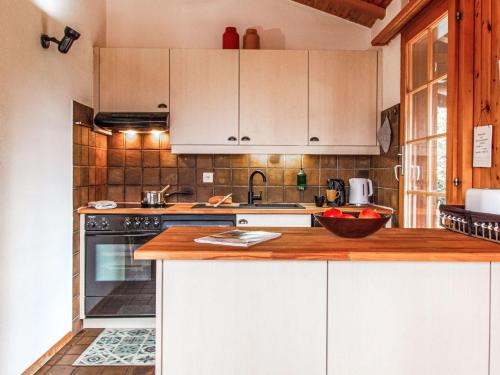 a kitchen with white cabinets and a wooden counter top at Chalet La Couronne by Interhome in Nendaz