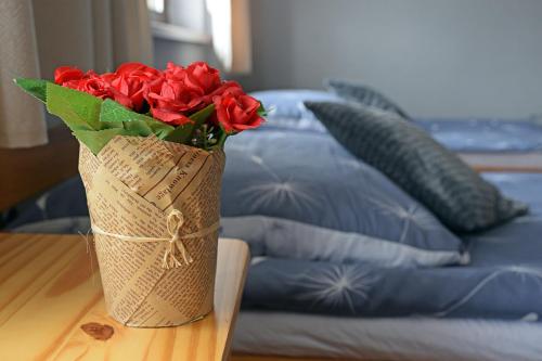 a vase filled with red roses sitting on a table at Pokoje Gościnne u Wioli in Jurgów