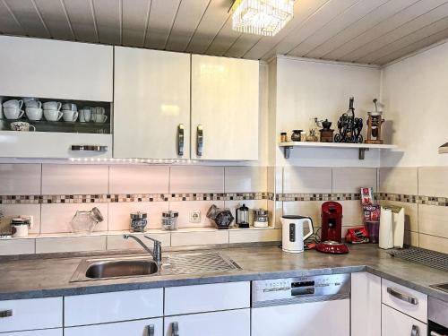 a kitchen with white cabinets and a sink at Apartment Ferienwohnung Renata 1 nahe Nürburgring by Interhome in Quiddelbach